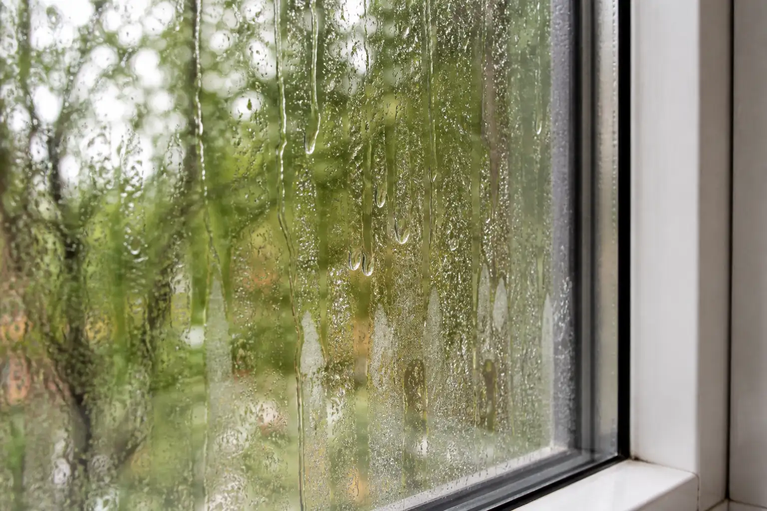 Angefeuchtete Fensterscheibe mit ablaufendem Wasserfilm